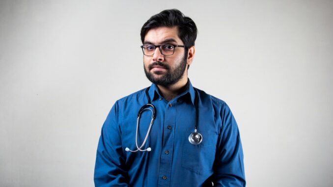 man in blue dress shirt wearing black framed eyeglasses