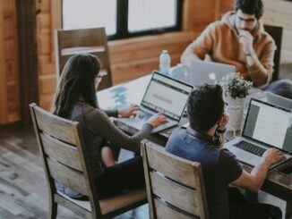 selective focus photography of woman and man using MacBook Pro on table